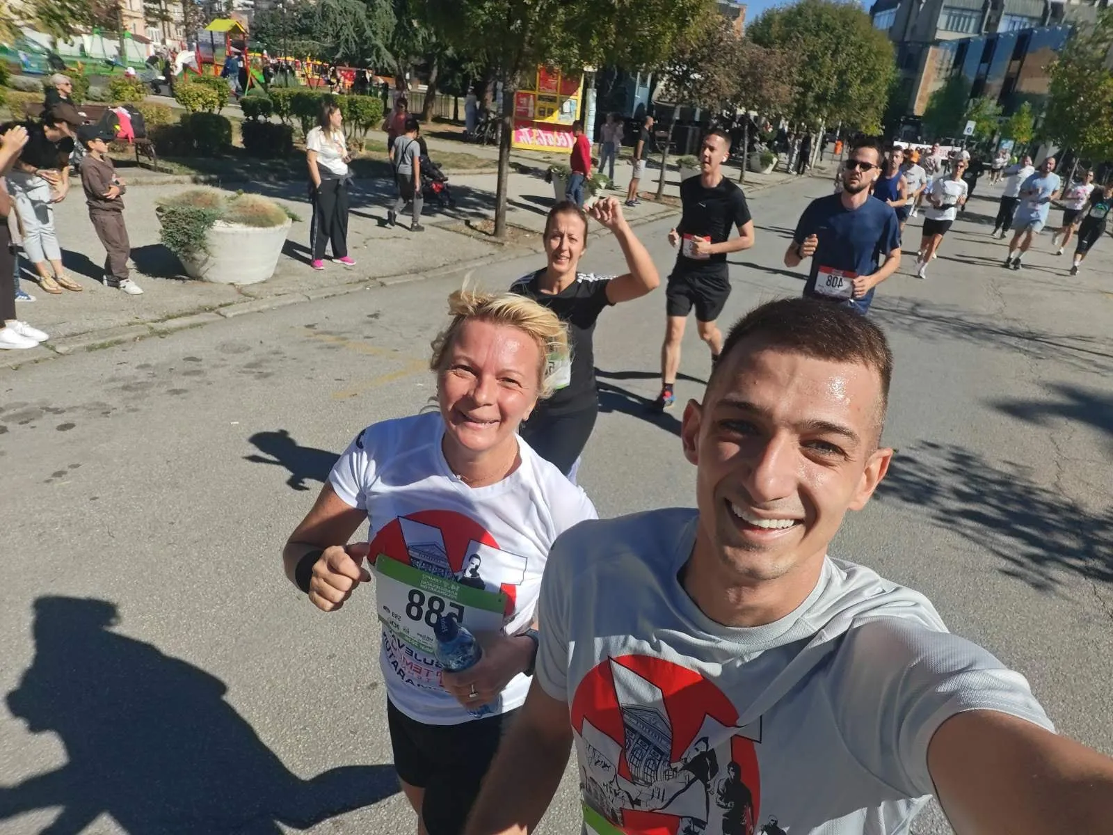 Selfi u trci: Violeta Mišić podiže palac, pored se smeje Stefan Paločević, a iza podiže ruku Nataša Đorđević, među drugim trkačima.
