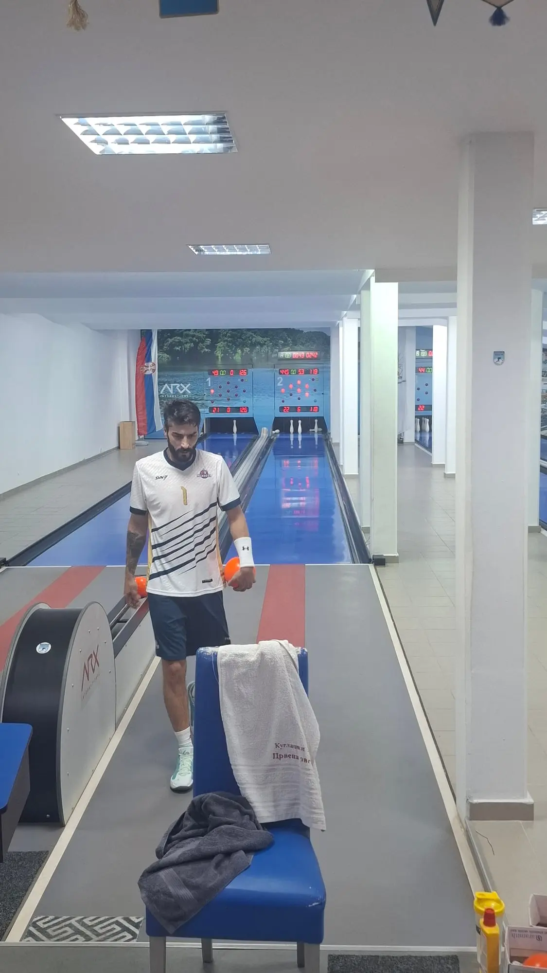 Miloš Simijonović ide ka kameri sa dve kugle u rukama, iza su staza 2 i semafor.