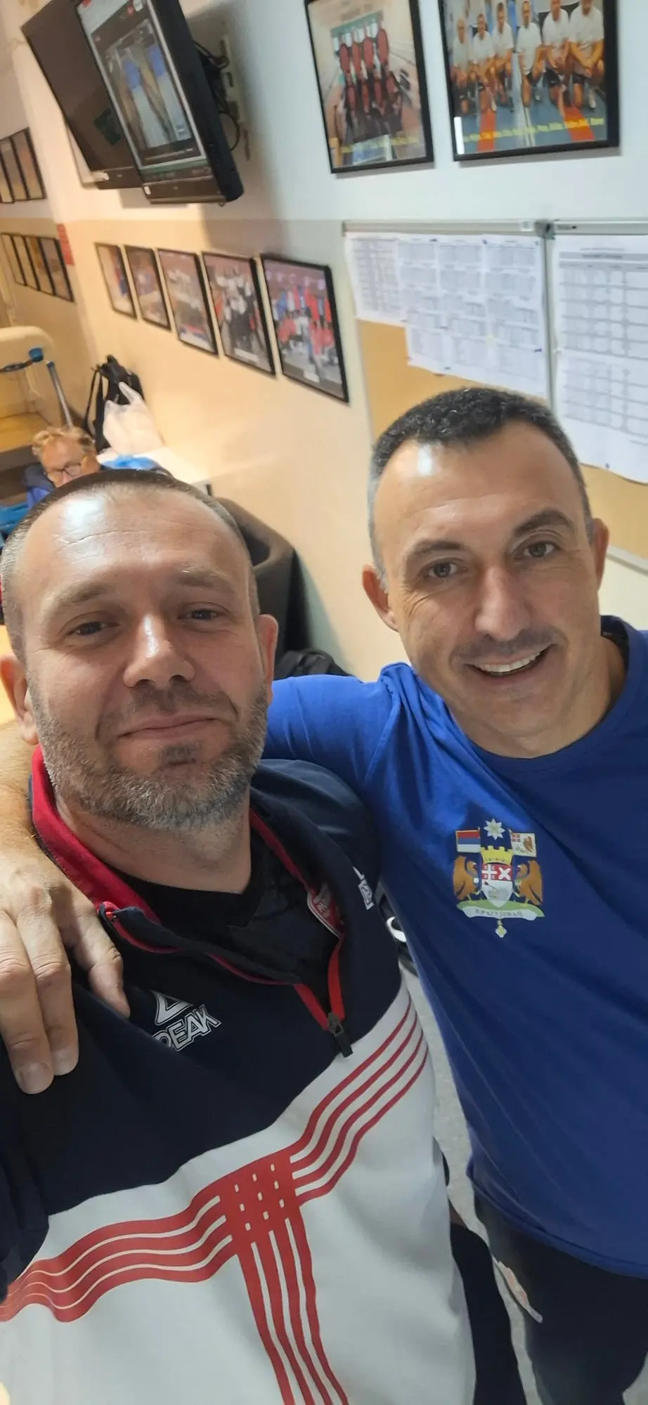 Dvojica muškaraca se slikaju zagrljeni, jedan u trenerci Mladosti, drugi u plavoj majici sa grbom Kragujevca.